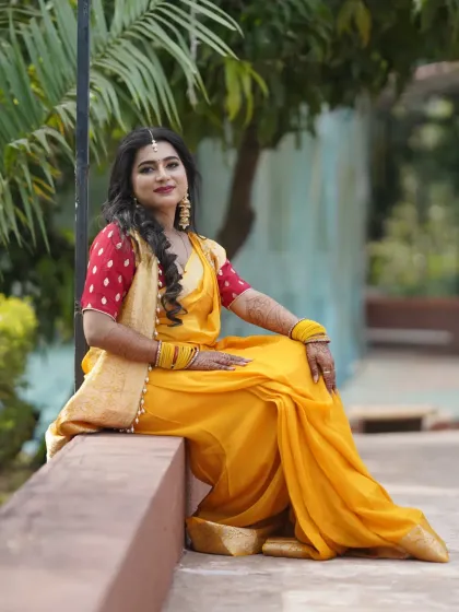 A beautiful Haldi look in a yellow saree with a contrasting red blouse. The makeup is fresh and minimal.