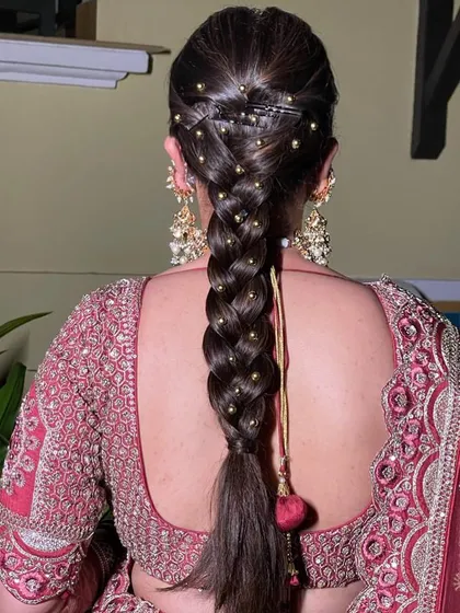 A simple, neat braid with small gold beads woven through, created for an early morning wedding. This style is traditional, elegant, and very secure.