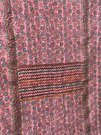 A detailed shot of the chevron-patterned fabric used in the pink saree quilt.