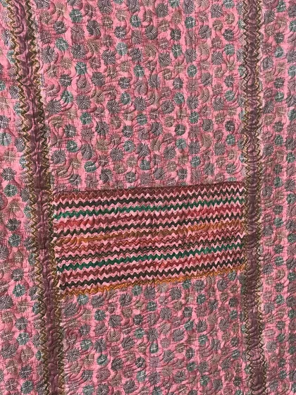 A detailed shot of the chevron-patterned fabric used in the pink saree quilt.