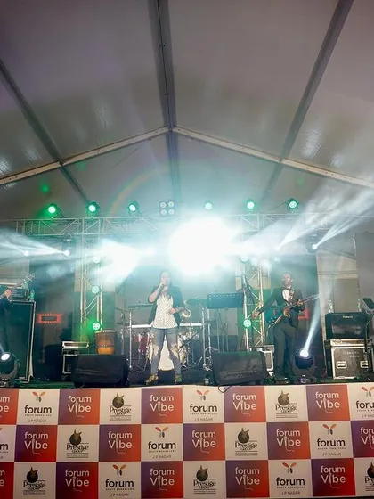 The band on a fully lit stage at Forum Vibe. We bring a complete audio-visual experience to every performance.