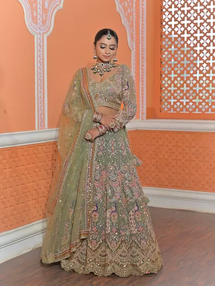 A graceful pose showing the full length of the embroidered lehenga and dupatta, with the jewellery providing the perfect finishing touch.