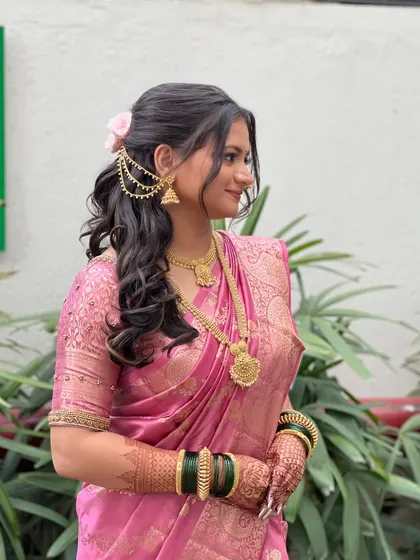 A side profile of Shruti, showing her elegant half-up hairstyle with a floral accessory.