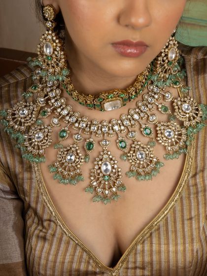 A close-up view of our regal Kundan bridal set. The image highlights the layered choker and necklace, showcasing the intricate craftsmanship and the beautiful combination of Kundan stones and light green emerald beads.
