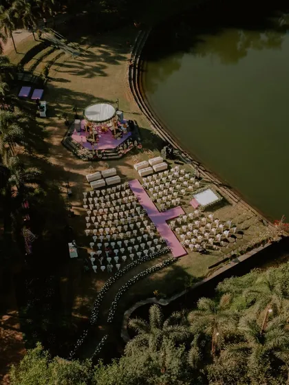 The complete wedding setup by the lake at Oleander Farms, seen from above. This drone shot showcases the meticulous planning and beautiful layout of a destination wedding.