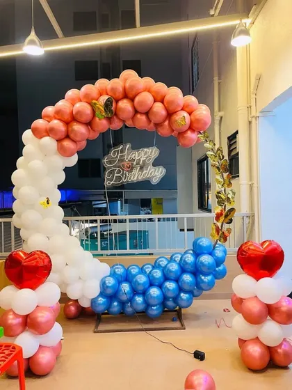 This crescent moon balloon arch offers a unique twist on the classic ring. Decorated with pink, white, and blue chrome balloons and a 'Happy Birthday' sign, it creates a magical and dreamy photo backdrop.