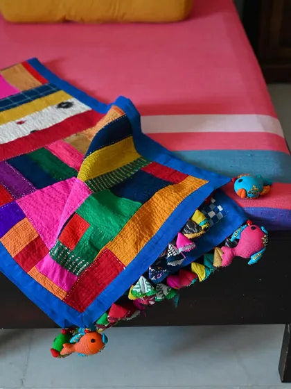 This shot highlights the fun, handmade tassels and the beautiful texture created by the patchwork and quilting.