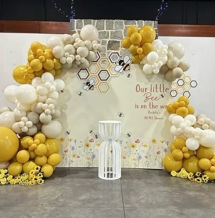 An alternate view of the charming bee-themed baby shower, showcasing the full setup with a small wishing well prop.
