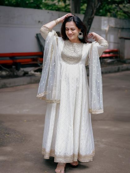 A full-length shot of the white Anarkali, showing its flowy silhouette and the delicate sheer dupatta.