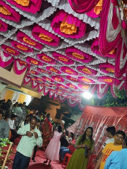 A lively crowd at the Airoli Gaon event, showing the festive atmosphere created by the pandal and decorations.