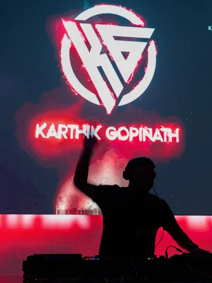 My custom KG logo blazing on the screen behind me. This silhouette shot captures the essence of my brand: bold, energetic, and always at the center of the party.