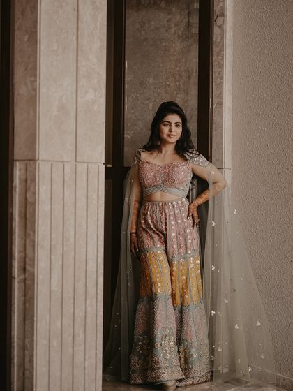 A full-length portrait showcasing a unique and stylish outfit. The bride looks confident and chic in her pastel sharara set, a perfect look for a pre-wedding event.