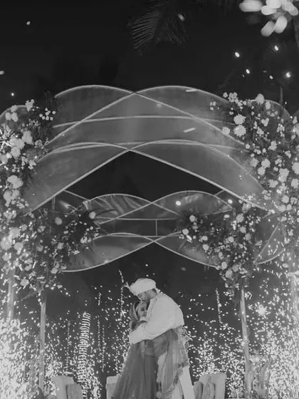 The same magical moment in timeless black and white, emphasizing the emotion and the dramatic sparkle of the pyrotechnics against the night.