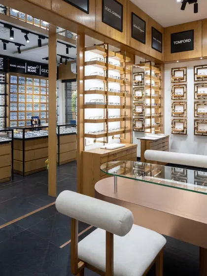 An overview of the store's interior, showing the custom-designed seating and consultation desk, which features a curved rose gold metal base and glass top.