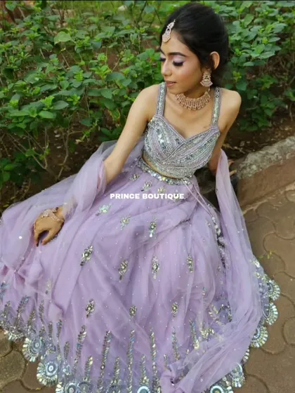 A beautiful seated portrait in the lavender lehenga, showing the intricate silver work on the skirt and the heavily embellished blouse.