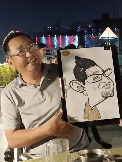 A guest enjoying the rooftop view and his new caricature at Mountain High.