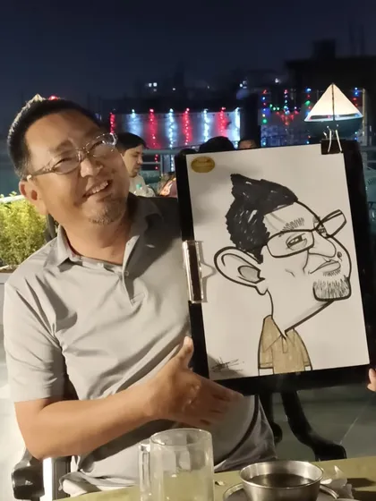 A guest at Mountain High restaurant, happy with his portrait. The city lights in the background create a nice ambiance.