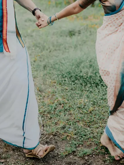A detail shot focusing on the couple holding hands as they walk. This simple image symbolizes their journey together, highlighting the connection in a subtle, beautiful way.