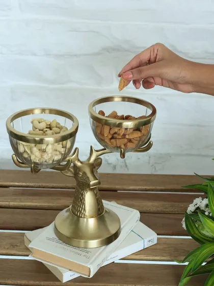 The regal reindeer bowl stand, featuring two glass bowls held by a majestic golden reindeer. This enchanting piece is perfect for serving nuts and snacks, adding a touch of woodland charm to your home.