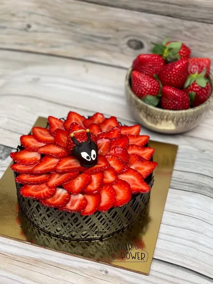 During strawberry season, I make this beautiful chocolate strawberry cake, covered in fresh sliced strawberries and a cute chocolate-dipped strawberry ladybug.