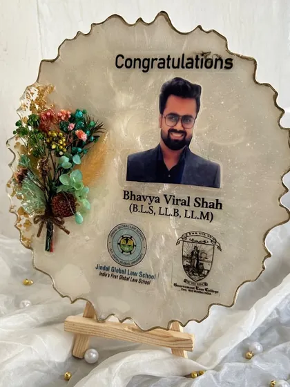 The graduation frame, a perfect way to commemorate years of hard work. The design includes the graduate's photo, qualifications, and university logos.