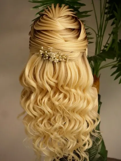An engagement hairstyle for a wedding day occasion. This beautiful half-updo features a textured top and soft, flowing curls for a romantic and dreamy look.