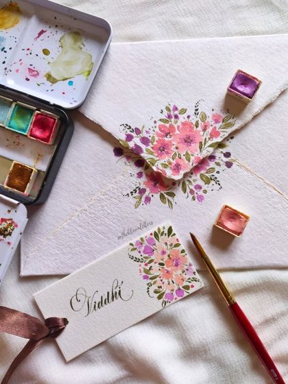 The process of creating one of the Guru Purnima tags, showing my watercolor palette and the delicate brushwork involved.