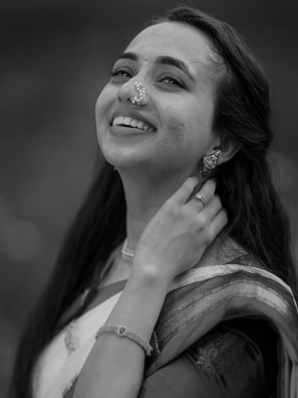 A timeless black and white portrait of a bride during her Haldi, her joyful expression and the smear of turmeric on her cheek telling a beautiful story.