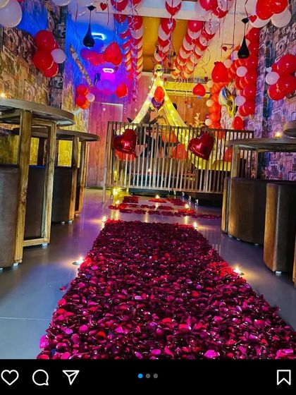 A restaurant cabin transformed into a private romantic escape. We created a pathway of rose petals leading to a secluded table, with the ceiling decorated with red balloons.