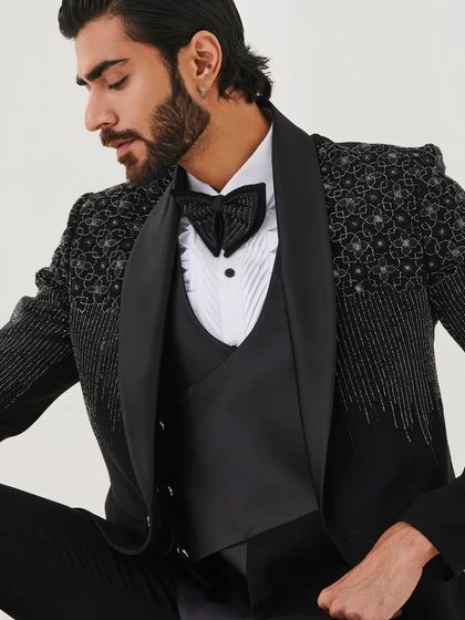 A seated pose in the gradient sequin tuxedo, showing the detail on the shoulders and the perfectly coordinated bow tie.
