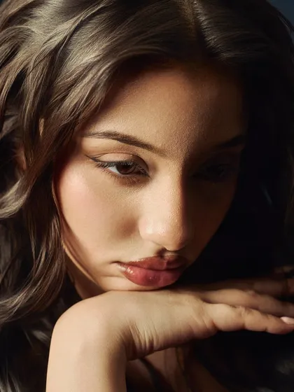An intimate and gentle beauty close-up. The focus is on the model's pensive expression, with soft light creating a quiet, contemplative mood.
