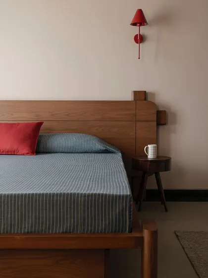 We introduced a pop of vermillion red in this kids' bedroom in Apartment 1005 to add a playful touch. The custom wooden bed frame features clean, modern lines, creating a space that is both fun and timeless.