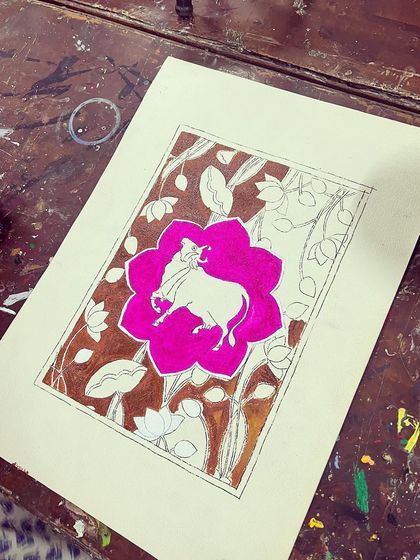 A Pichwai painting in progress. The vibrant pink lotus is filled in, and the intricate background is ready for color.