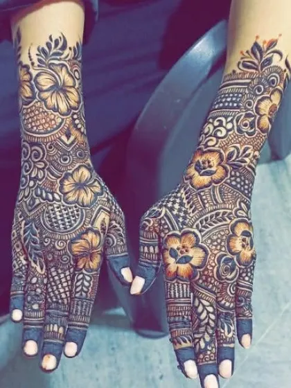 A full coverage design featuring hibiscus flowers and geometric patterns. The dark fingertips are a classic bridal touch.