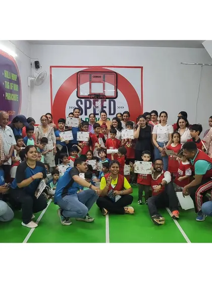 A proud moment for everyone. A group photo with kids holding their certificates after a successful athletics competition.
