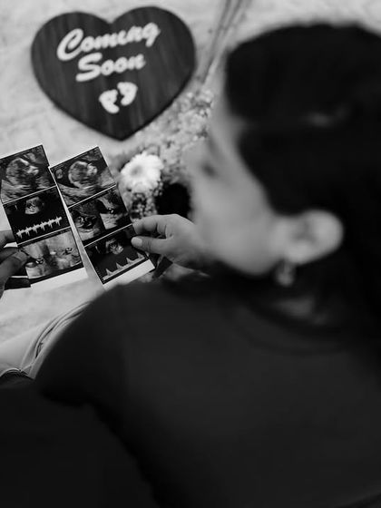 A black and white overhead shot of the couple looking at their sonogram pictures, surrounded by props like a ukulele and flowers. It’s a snapshot of their happy preparations.