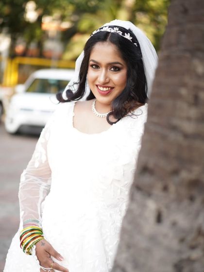 A candid outdoor shot of the bride. Her makeup looks fresh and radiant even in natural daylight, a testament to the quality of the products and techniques used.