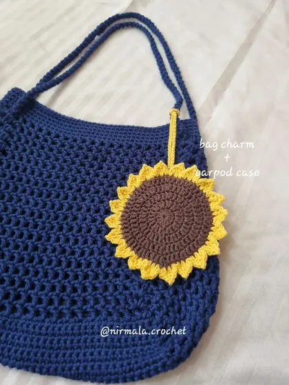 A still shot of our sunflower beach bag. The sunflower doubles as a bag charm and a small pouch for your Airpods or other tiny items.