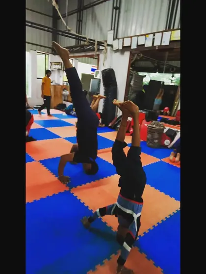 Students practicing their headstands on the mats. Consistent practice is the only way to master balance and make inversions feel natural.