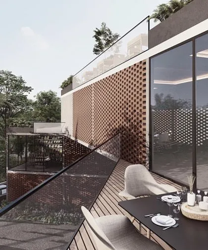 The terrace of the Kolgaon clubhouse provides an open-air dining and lounge area. The design uses perforated screens and glass railings to maintain a visual connection to the surrounding landscape while defining a distinct, elevated social space.