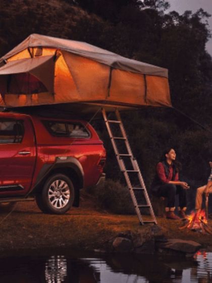 A lifestyle shot for the Toyota Hilux campaign, styled for a camping scenario. The comfortable, layered outdoor wear on the models helps create an authentic scene of enjoying nature with the help of a capable vehicle.