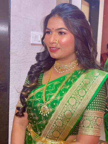 A stunning traditional look in a vibrant green saree, paired with classic gold jewelry and a radiant makeup finish.
