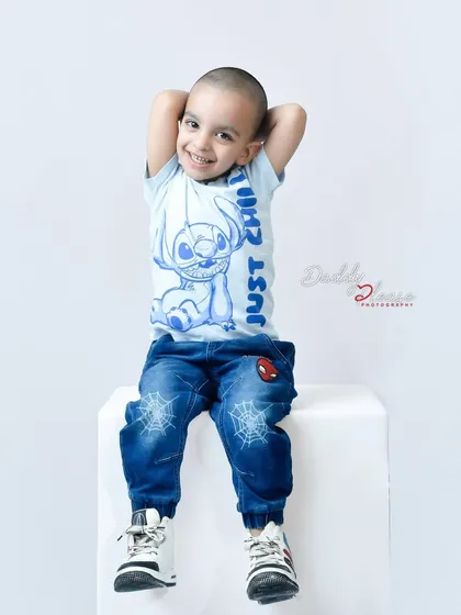 A relaxed and happy portrait of a boy in a "Just Chill" t-shirt, taken during his birthday studio session. His comfortable pose and smile show he's having a great time.