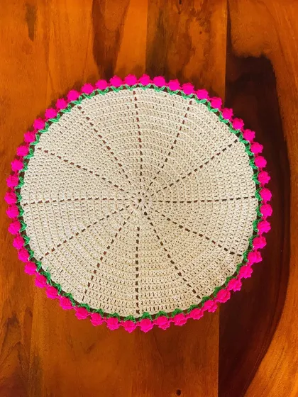 A top-down view of the cream and pink tulip doily, a fresh and pretty design.