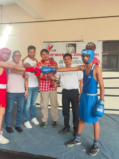 Two young competitors facing off in the ring during a local boxing championship, with officials ensuring a fair and safe bout.