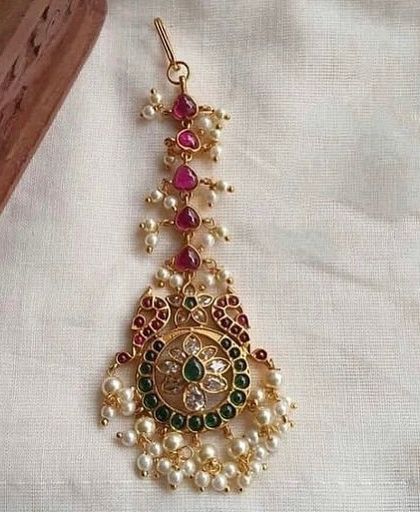 A delicate maang tikka with kemp stones and pearl drops. This is a perfect rental piece for bridesmaids or for pre-wedding functions.