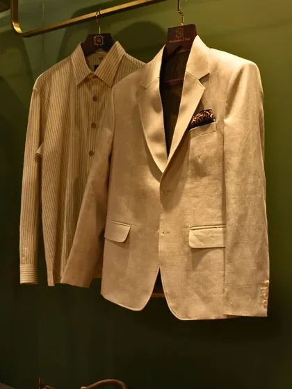 Another view of the beige blazer and striped shirt, emphasizing the clean lines and quality fabric. This is a timeless pairing for smart-casual events.