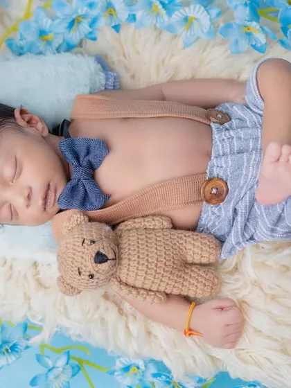 A top-down view of the sleeping baby, showing off the cute bow tie and suspenders.