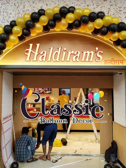 A bold black and yellow balloon arch designed to match Haldiram's brand colors. We specialize in creating branded entrance decor that reinforces your company's identity during promotional events.