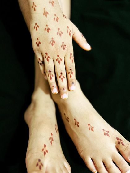 A minimalist design for both hands and feet, featuring small, scattered leaf motifs.